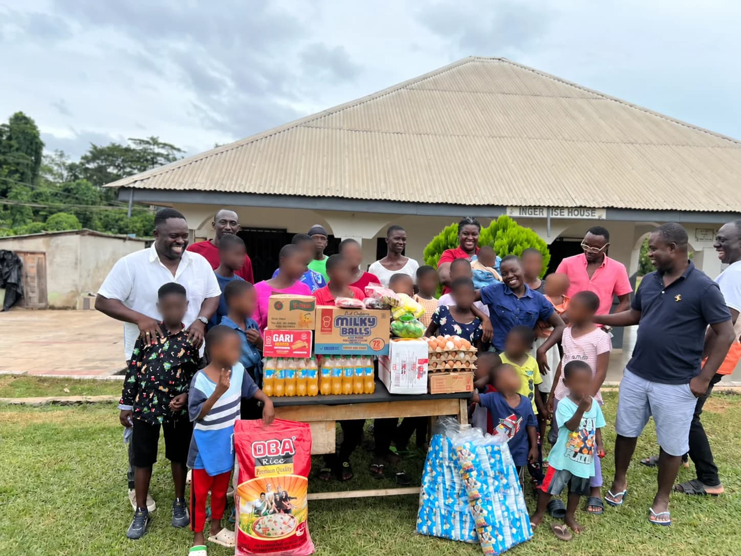 Participants and donated food and supplies at Caring Home Village